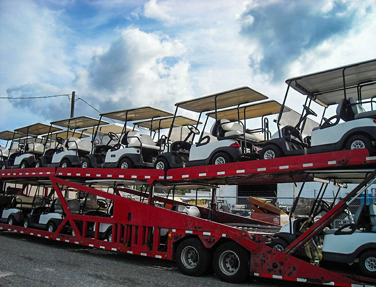 White golf carts on double decker trailer image