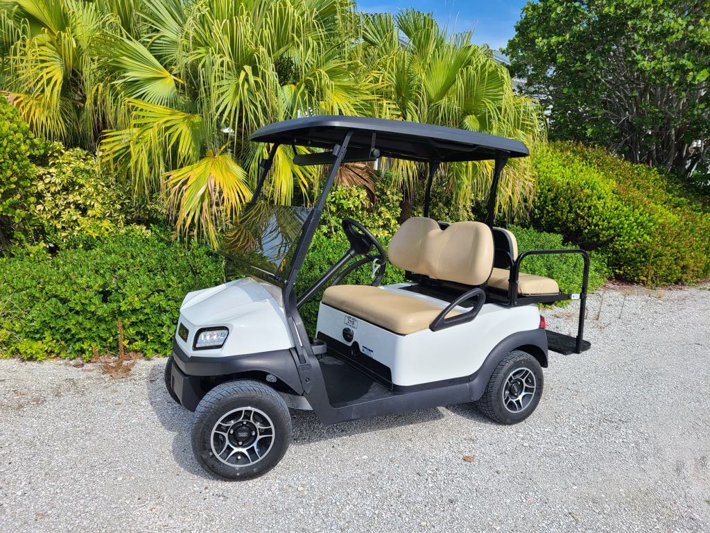 caddy carts golf cart rentals in Boca Grande Florida. white club car golf cart on a Boca Grande path with green palm trees.